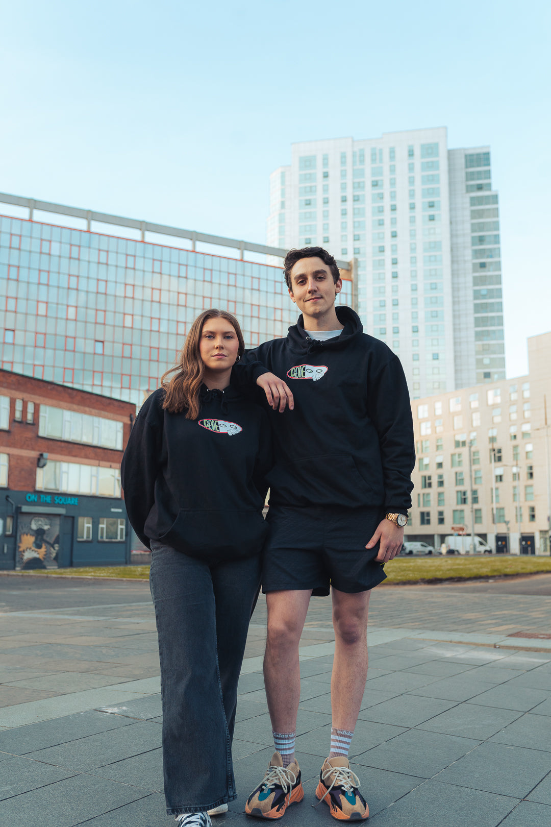 man and woman wearing black graphic hooded sweatshirt