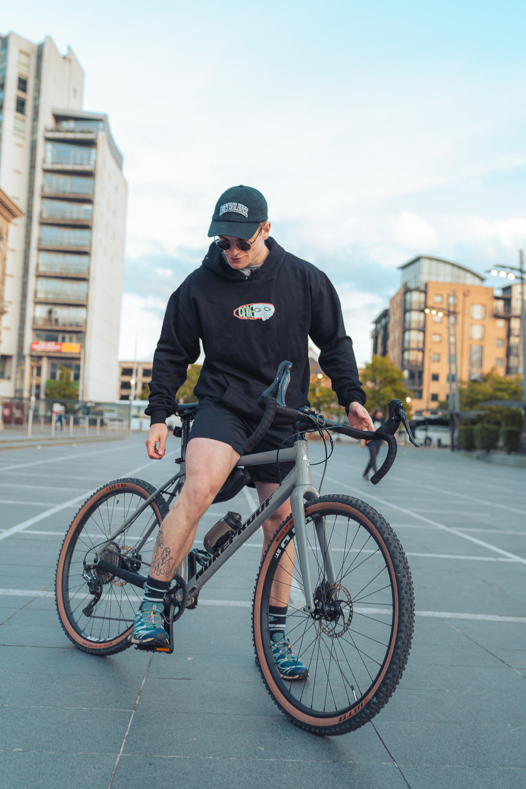 man wearing black graphic hooded sweatshirt on bicycle